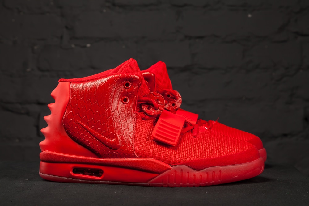 Nike Air Yeezy 2 Red October or Solar Red. New beautiful colorful and nice Nike Air Max running shoes, sneakers, trainers shows the logo with a brand box on abstract background. Sport and casual footwear concept.